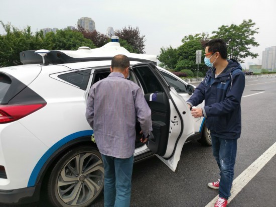 长沙梅溪湖国际文化艺术中心附近,一位市民在随车安全员引导下,准备登车试乘百度阿波罗自动驾驶出租车。新华社记者刘良恒 摄